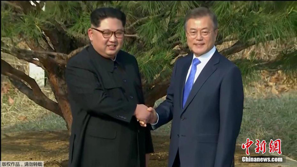 South Korean President Moon Jae-in （R）and Kim Jong Un, top leader of the Democratic People's Republic of Korea (DPRK), shake hands after planting a pine tree beside a path near the military demarcation line, April 27, 2018. (Photo/TV screenshot)