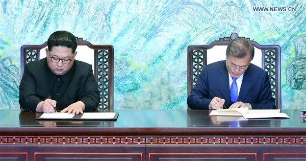 South Korean President Moon Jae-in (R) and Kim Jong Un, top leader of the Democratic People's Republic of Korea (DPRK) sign for their joint declaration, titled the Panmunjom Declaration for Peace, Prosperity and Unification of the Korean Peninsula, at Peace House on the South Korean side of Panmunjom, on April 27, 2018. (Xinhua/Inter-Korean Summit Press Corps)