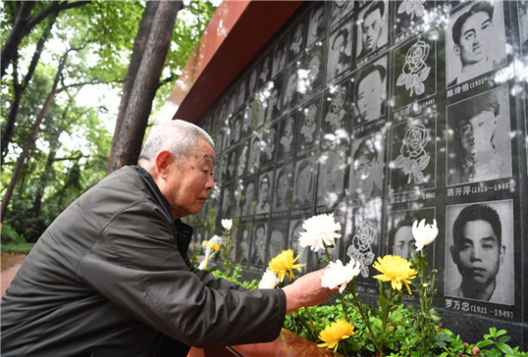 A resident in Chongqing presents a flower to commemorate martyrs at a Gele Mountain Cemetery of Revolutionary Martyrs in Southwest China on April 6, 2018. (Photo/Xinhua)