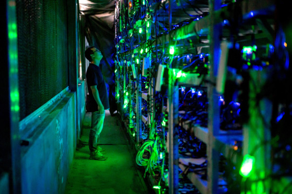 A technician checks mining equipment at a bitcoin mine in Sichuan province. (Photo provided to China Daily)