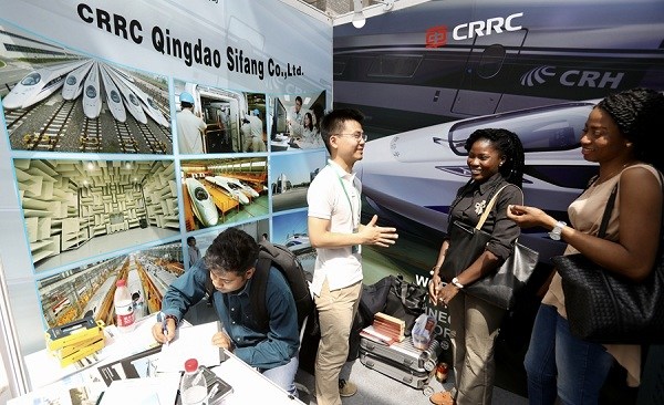 An employee from China Railway Rolling Stock Corp chats with two women at a job fair for international students at Peking University. (Zhu Xingxin/China Daily)