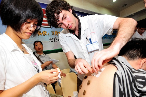 An Australian intern treats a patient at the Zhejiang Hospital of Traditional Chinese Medicine in Hangzhou. (Liu Chen/China Daily)