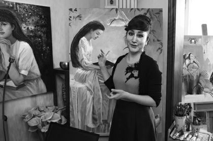 Yan Zi introduces an oil painting explaining the relationship between crested ibis and humans at her home in Xi'an. (Photo by Huo Yan/China Daily)