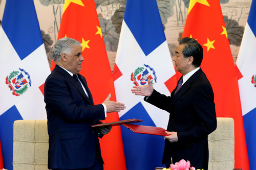 State Councilor and Foreign Minister Wang Yi and Dominican Republic Foreign Minister Miguel Vargas Maldonado seal the deal they just signed on Tuesday on diplomatic relations at the Diaoyutai State Guesthouse in Beijing. (Photo/CHINA DAILY)
