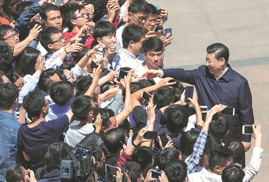President Xi Jinping shakes hands and is photographed with students during his visit to Peking University on Wednesday. The president spoke about the university's achievements over the past 120 years. (Photo/Xinhua))