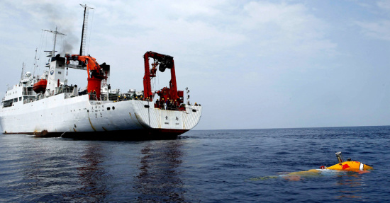 Qianlong 3, China's newest unmanned submersible, surfaces astern of its mother ship, the Dayang Yihao, or Ocean No 1, on April 25. The ship returned to the port at Qingdao after the 45-day trip, during which the submersible made 12 dives. (Photo/Xinhua)