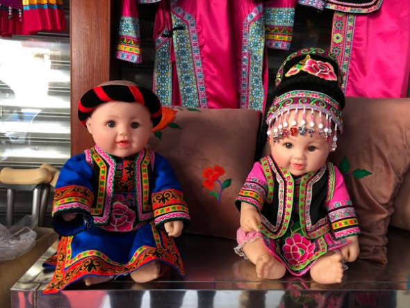 Two dolls wearing Qiang ethnic costumes are displayed at Chens shop in Yanmen. (Photo: chinadaily.com.cn/Yao Yao)
