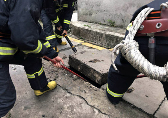 Firefighters dig into a tunnel covered by concrete slabs in Zhanjiang, Guangdong province, to rescue a cat. Photo/CHINA DAILY BY XIASHAN FIRE BRIGADE ONLINE