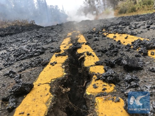 Cracks and volcanic debris are seen on a road in Leilani Estate, Hawaii, U.S., May 9, 2018. According to reports of the Hawaii State government, eruptions of the Kilauea Volcano had forced the evacuation of thousands of people. (Xinhua/Tao Xiyi)