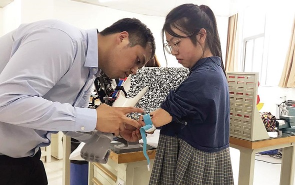Hong Kong charity Stand TALL has provided free prosthetic therapy for Zhou Yuye and other Wenchuan earthquake survivors for 10 years. They intend to provide a bionic arm for Zhou this year. (Nora Zheng/China Daily)
