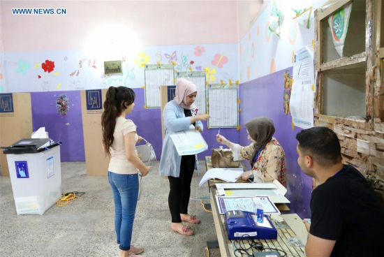 A voter votes at a polling station in Baghdad, Iraq, May 12, 2018. Iraq's Independent Electoral Commission (IHEC) said on Saturday that the turnout in the parliamentary election has reached 44.5 percent with votes of over 4,000 polling stations still uncounted. (Xinhua/Khalil Dawood)