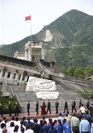 At the site of Xuankou Middle School, people gather on Saturday for a memorial service marking the 10th anniversary of the Wenchuan Earthquake in Sichuan province that killed nearly 70,000 people. [Photo by ZOU HONG/CHINA DAILY