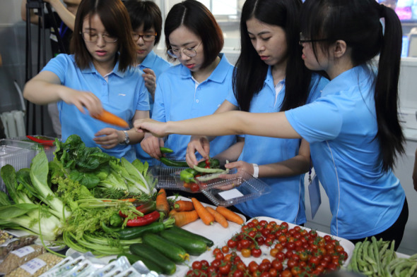 Produce grown in the Lunar Palace 1 Bioregenerative Life-Support Laboratory in Beijing is shown by experiment assistants at the project's conclusion on Tuesday. It was the world's longest experiment in a self-sustaining ecosystem. (WANG JING/CHINA DAILY)
