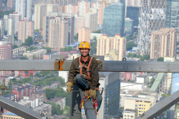 Migrant construction worker Chen Jiankang is on the job on May 1 at the China Zun skyscraper in Beijing. (Photo/Xinhua)