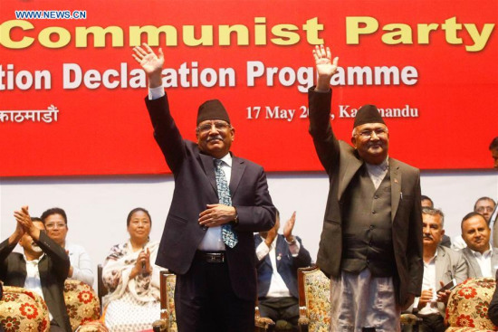 Chairman of Communist Party of Nepal (United Marxist Leninist) (CPN-UML) KP Sharma Oli (right) and Chairman of Communist Party of Nepal (Maoist Centre) Pushpa Kamal Dahal wave after announcing the unification of the two parties in Kathmandu, Nepal, on May 17, 2018. (Photo/Xinhua)