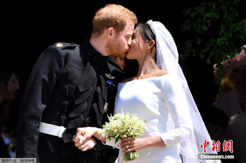 Britain's Prince Harry (L) and Meghan Markle (R) kiss as they exit St George's Chapel in Windsor Castle after their royal wedding ceremony, in Windsor, Britain, May 19, 2018. The couple have been bestowed the royal titles of Duke and Duchess of Sussex on them by the British monarch. (Photo/China News Service)