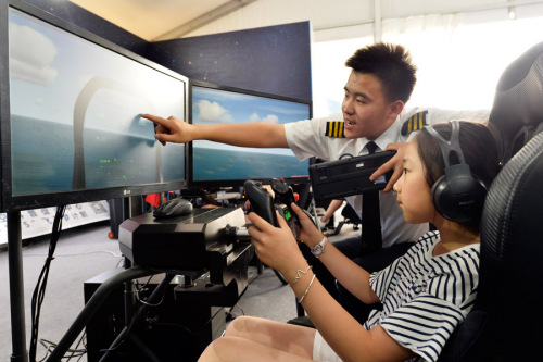 A student takes the controls of a flight simulator at the launch of the 18th National Science and Technology Week on Saturday in Beijing. (Photo by Wang Jingsheng/Xinhua)