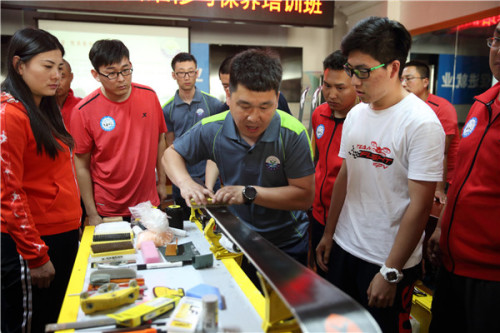 A technician shows how to wax a ski properly during a training session for members of the Haituo 