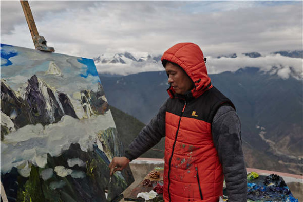 Zhou Changxin paints during a trip to the Meili Snow Mountain in Yunnan province. (Photo provided to China Daily)