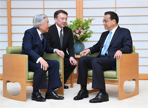 Premier Li Keqiang engages in conversation on Thursday with Japan's Emperor Akihito (left) at the Imperial Palace in Tokyo. He said he hoped bilateral ties improve. It was the first time a Chinese premier has met with the emperor since June 2010. Akihito said he hopes "our relations of goodwill and friendship will improve", according to the royal household. (Photo/Xinhua)