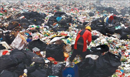Is there anything useful in all this garbage? A scavenger, working through a Beijing landfill earlier this month, is one of many who live on the waste they can recycle. [Photo / China Daily] 