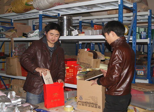 Yuan Chenglong (left) and an employee package goods he sells online. He is a beneficiary of loans through ppdai.com, a Shanghai-based website that facilitates private lending. Provided to China Daily 