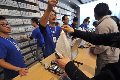 Workers at the Hong Kong Apple Store give customers their Apple iPhone 4S on Nov 11. The iPhone 4S was released on that day in Hong Kong. Aaron Tam / AFP 