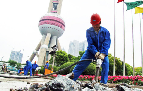 A construction site near the Oriental Pearl TV Tower in Shanghai. Revenues from land sales in Shanghai and Beijing are expected to decline this year, since there is no sign that curbs on the property market will ease. [Photo / China Daily]