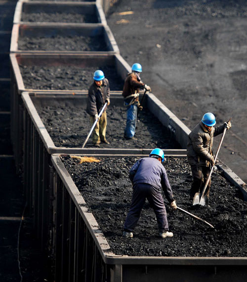 Workers load coal at a railway station in Jiujiang, Jiangxi province. China's consumption of fossil fuels such as coal and oil dropped slightly last year, while its production of clean energy increased.[Photo/China Daily]