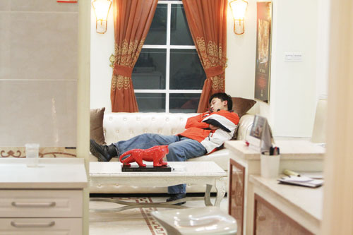 A sales person asleep on a couch in a home decoration market in Qingdao, Shandong province. China's property market rein-in policy slowed down its home products sector. [Photo/ China Daily]