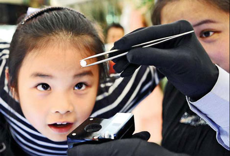A young customer is impressed with a 1.54-carat diamond worth 320,000 yuan ($50,900) at a department store in Dongyang city, Zhejiang province. China has seen noticeable growth in demand coupled with rising interest in the gemstone as an investment product. [Photo/China Daily]