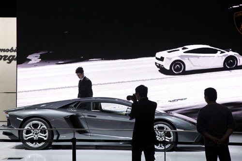 Visitors take pictures of the Automobili Lamborghini SpA Aventador vehicle displayed at the Auto Shanghai 2011 car show in Shanghai, China. [Photo/Agencies]
