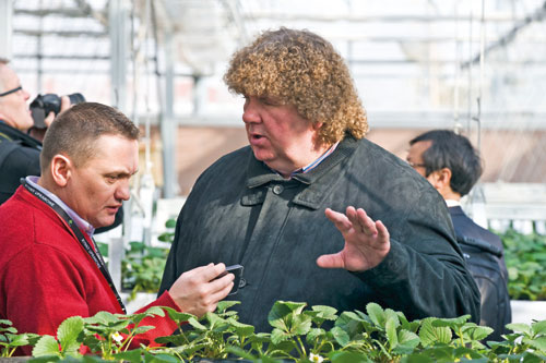 Two foreign business people discussing strawberry planting technology and varieties at the seventh International Strawberry Symposium that started on Feb 18 in Beijing. Antonio Ruffo, chief executive officer of Fruitgrowing Equipment and Service Srl, an Italian company, said he sees great potential for his strawberry business in China. [Photo/China Daily]