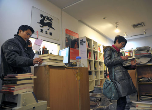 Customers browse the shelves of Longzhimei Advertisement Bookstore in Shanghai on Monday, before it closes for business. [Photo/China Daily]