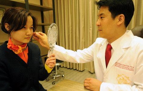 A South Korean doctor at Yanda International Hospital in Sanhe city of Hebei province examines a patient's condition before a double-eyelid operation in May last year. [Photo / Xinhua] 