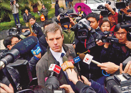 Graham Michael Robinson, witness for tech company Apple, is surrounded by reporters outside the Guangdong High People's Court in Guangzhou, Guangdong province, on Wednesday, as the court held a public hearing on the iPad trademark dispute. [China News]