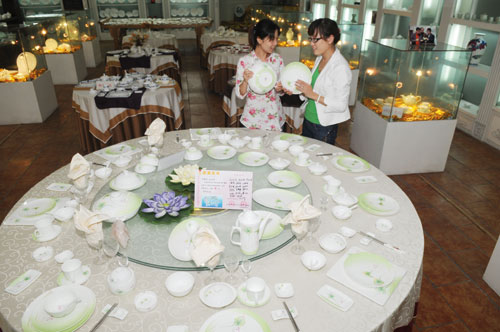 A customer selecting tableware at a ceramics exhibition in Zibo, Shandong province. Some Chinese household ceramics companies are preparing a legal response to an EU anti-dumping investigation.[Photo/China Daily]