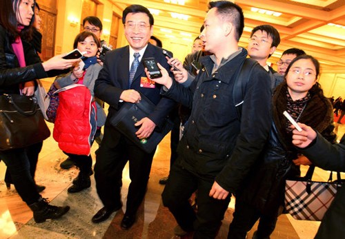 Minister of Industry and Information Technology Miao Wei (center) surrounded by journalists at the Great Hall of the People in Beijing on Sunday during the fourth plenary meeting of the Fifth Session of the 11th National People's Congress. [Jiang Dong / C