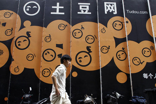 A pedestrian walks past the company logo of Tudou located outside their headquarters in Shanghai in this August 17, 2011 file photo. [Photo/Agencies]
