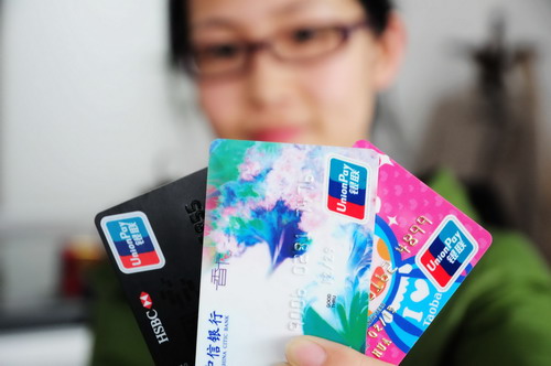 A woman displays credit cards in Qingdao, Shandong province. Credit cards have become a driver of domestic consumption, being used in 7.56 trillion yuan ($1.2 trillion) of retail purchases last year. [Photo/China Daily] 