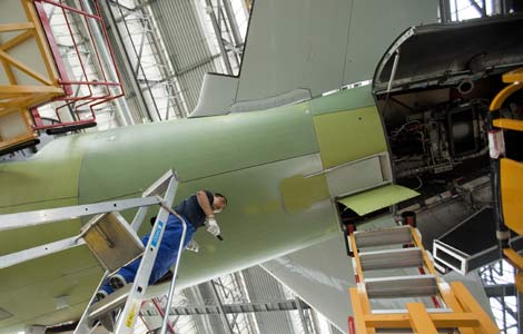 An Airbus SAS employee works on an A320 aircraft at the company's assembly facility in Tianjin. AirAsia Bhd, the region's biggest budget carrier, will become the first foreign airline to receive an A320 assembled in Tianjin in December. [Photo / Agencies]