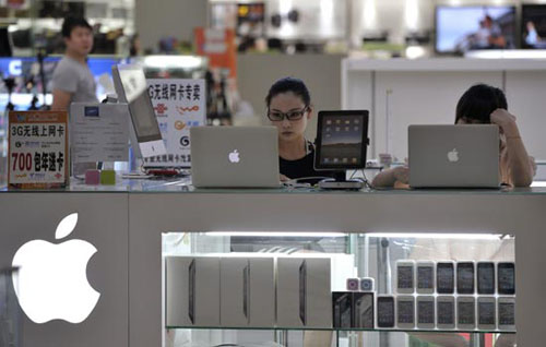 Customers test Apple MacBooks on sale at an electronic products market in Nanjing, Jiangsu province. The authorities are urging Apple Inc to unify its global standards of intellectual property protection. [Photo/Agencies] 