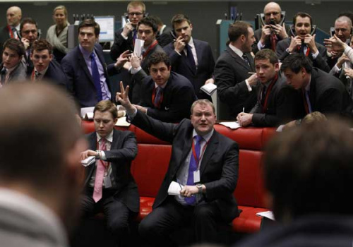 Traders and clerks react on the floor of the London Metal Exchange in the City of London February 14, 2012.