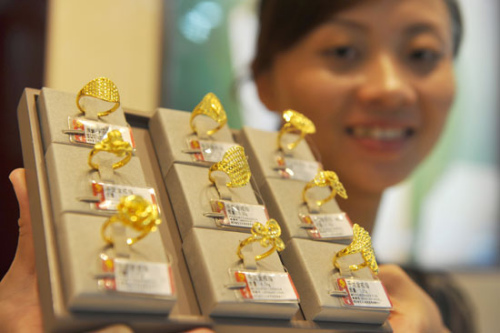 A saleswoman arranges jewelry at a shop in Qionghai, Hainan province. The World Gold Council said on Aug 16, 2012 that global gold purchases dropped 7 percent year-on-year in the second quarter, and predicted that China will be the biggest source of gold demand this year. [Photo / China Daily] 