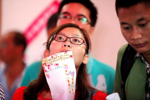 A jobseeker checks out job information attentively at a job fair for college graduates in Bozhou, Anhui province, Aug 18, 2012. A study found that working for a State-owned enterprise of local privately owned companies is becoming increasingly attractive,