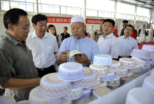 A staff member (middle) in charge of a Muslim clothing factory introduces their products to visitors on August 23, Wuzhong city, Ningxia Hui autonomous region. [Photo/Xinhua] 