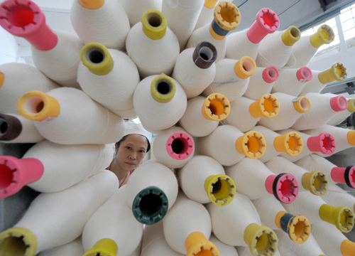 A textile worker at a mill in Nanyang, Henan province. China's textile industry is suffering losses because of decreasing overseas demand and rising costs. (Photo: Xinhua)