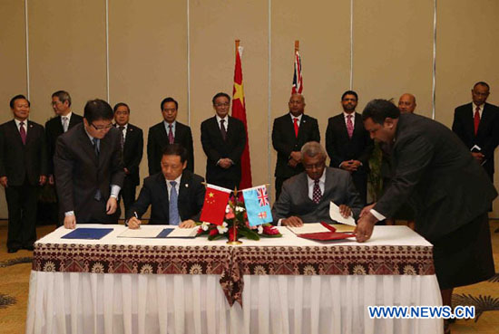 Wu Bangguo (5th L, back), chairman of the Standing Committee of China's National People's Congress, and Fiji's Prime Minister Josaia Voreqe Bainimarama (4th R, back) attend the signing ceremony of bilateral cooperation documents in Nandi, Fiji, Sept. 21, 