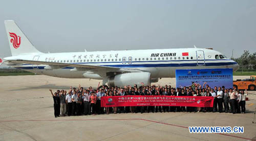 Staff members of Air China pose for photos in front of the 100th Airbus A320 family aircraft assembled in Tianjin at its delivery ceremony in Tianjin, north China, Sept. 25, 2012. A ceremony of the delivery of the 100th Airbus A320 family aircraft assembl