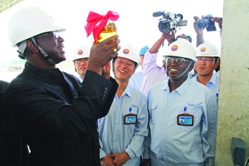 Chad's Prime Minister Emmanuel Nadingar holds a bottle of home produced gasoline. In 2011 April, CNPC's rig in Chad came on stream. Just four months later, the new refinery near N'Djamena was put into operation. For the first time in Chad's history, the country was able to feed itself with home produced gasoline and diesel. [Photo/China Daily]
